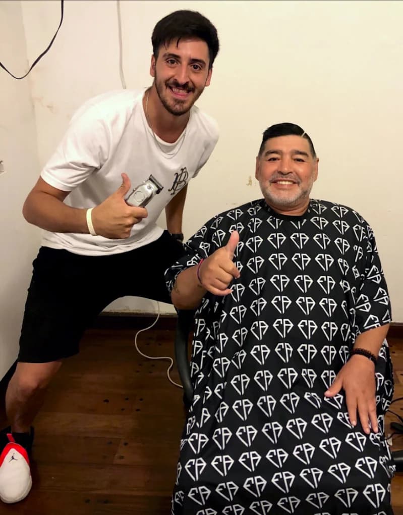 Fran, barbero de Diez Peluquería, cortándole el pelo a Diego Maradona.